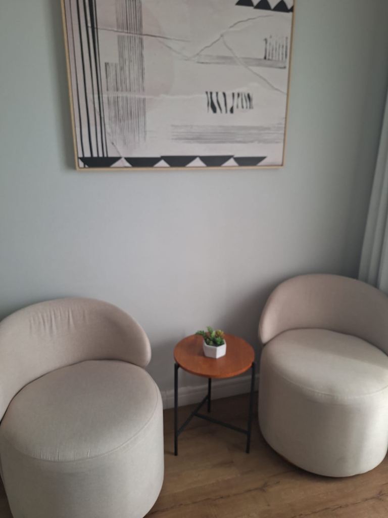 Detalhe do ambiente acolhedor e seguro do consultório com quadro decorativo